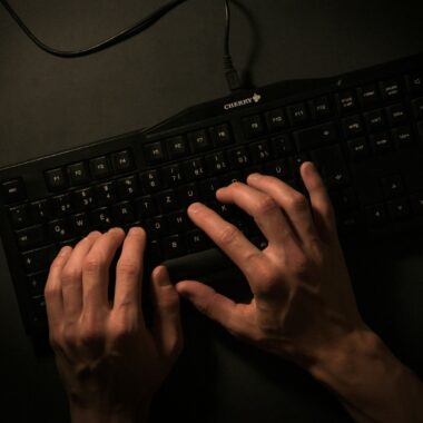 a person is typing on a black keyboard